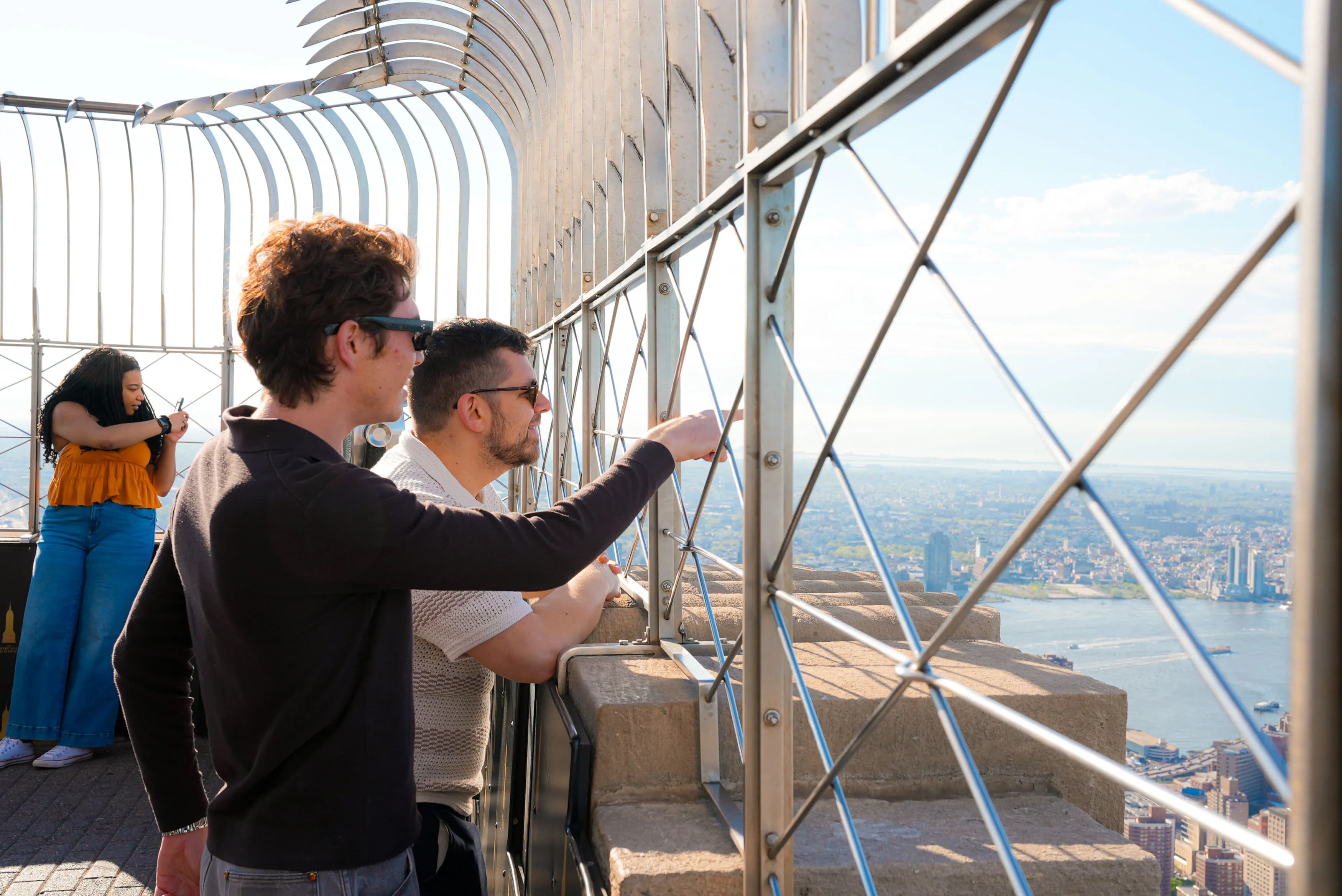 People pointing from the 86th Floor Observation Deck