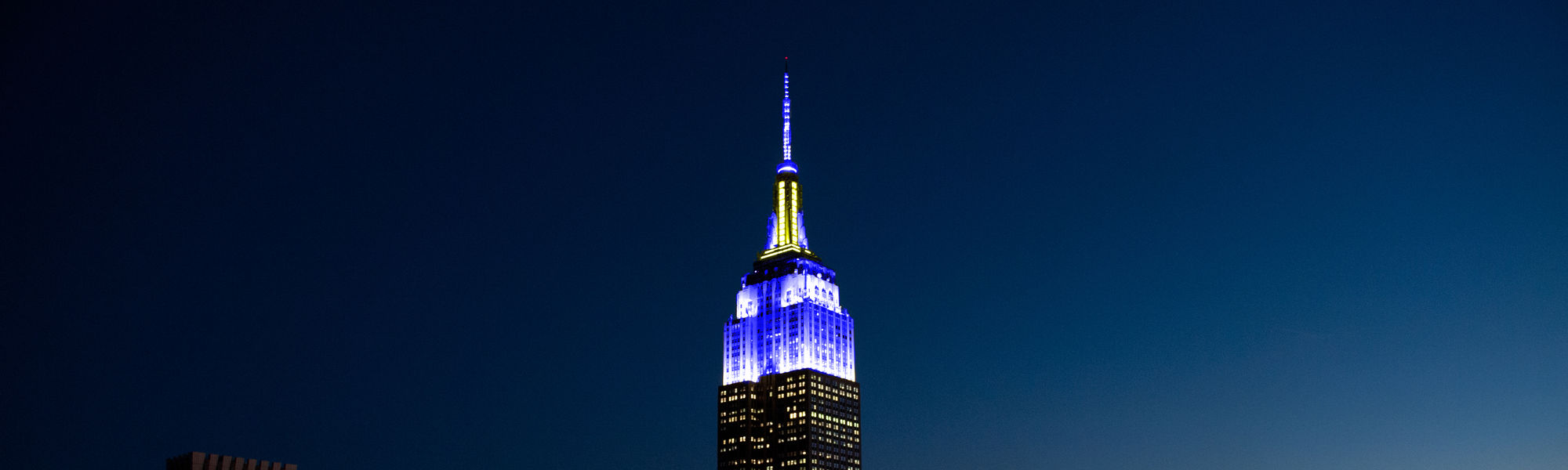 ESB lights in blue and yellow for Chuck Scarborough's 50th On-Air Anniversary