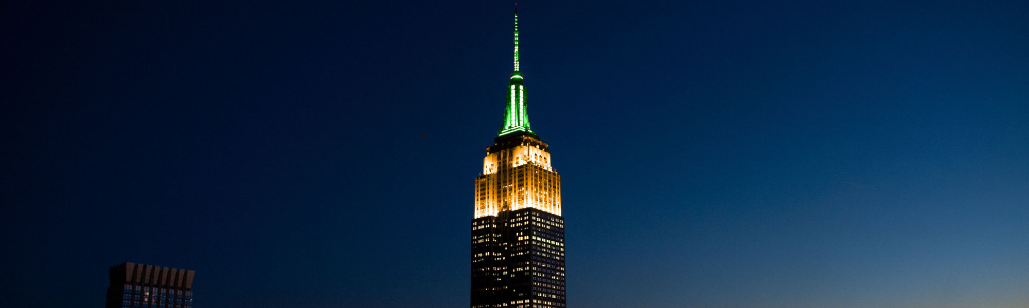 The Empire State Building lit in orange and green