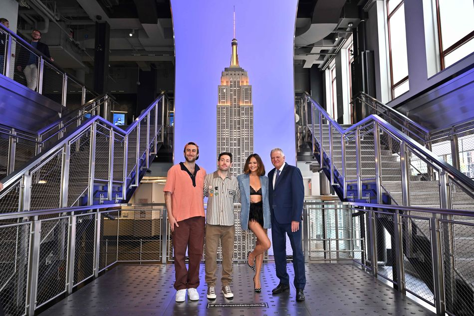 Two Friends and Chrissy Teigen pose in front of the ESB model